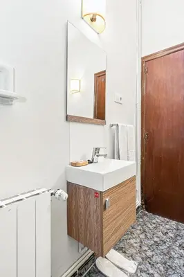 a bedroom with a mirror and a chair and a sink at Hostal Santa Ana in Barcelona
