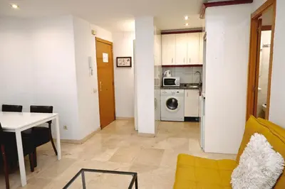 a living room with a table and a kitchen at Homenfun Barcelona Sagrada Familia Lepanto in Barcelona