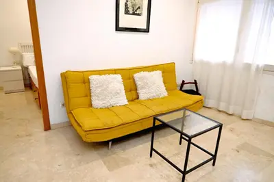a yellow couch in a living room with a table at Homenfun Barcelona Sagrada Familia Lepanto in Barcelona