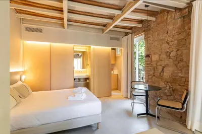 a bedroom with a bed and a table in a room at Decô Apartments Barcelona-Born St. in Barcelona