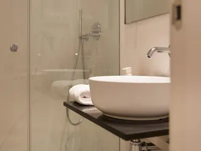 a bathroom with a sink and a glass shower at Decô Apartments Barcelona-Born Apt. in Barcelona