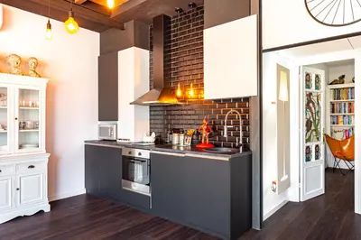 a kitchen with a stove and a brick wall at Luxury Penthouses 1 in Barcelona