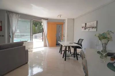 a kitchen and living room with a table and chairs at BlueLine 25km BCN-Piscina, sauna y vistas al mar in Mataró
