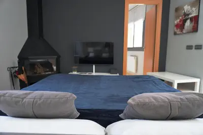a bedroom with a blue bed and a tv at BlueLine 25km BCN-Piscina, sauna y vistas al mar in Mataró