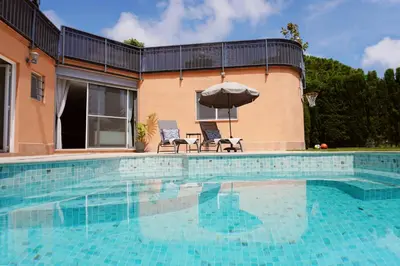 a swimming pool with two chairs and an umbrella at BlueLine 25km BCN-Piscina, sauna y vistas al mar in Mataró