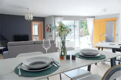a white table with plates and a vase of flowers on it at BlueLine 25km BCN-Piscina, sauna y vistas al mar in Mataró