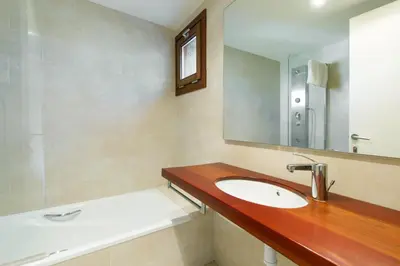 a bathroom with a sink and a mirror and a bath tub at Masia el Prat in El Pont de Vilomara