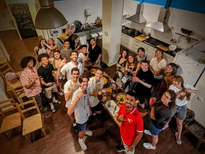 a group of people posing for a picture in a kitchen at 360 Hostel Centro in Barcelona