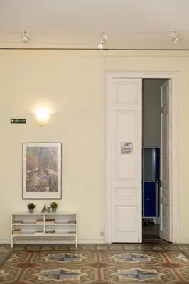 a white door with a sign on it next to a plant at 360 Hostel Centro in Barcelona