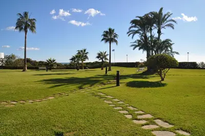 a stone path in a park with palm trees at GAVA4 BEACHFRONT Apartment BARCELONA in Gavà