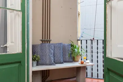 a bench with pillows and plants on a balcony at Key Barcelona HOUSING (Carrer Girona) in Barcelona
