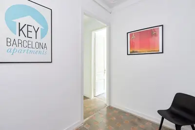 a black chair in a white room with a wall at Key Barcelona HOUSING (Carrer Girona) in Barcelona