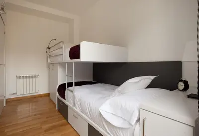 a bedroom with a bunk bed with white sheets and pillows at AB Gracia Sant Salvador in Barcelona
