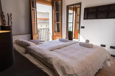 a large bed in a bedroom with a balcony at Inspired by EnjoyApartments in Barcelona