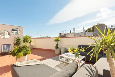 a living room with a couch and plants on a roof at Inspired by EnjoyApartments in Barcelona