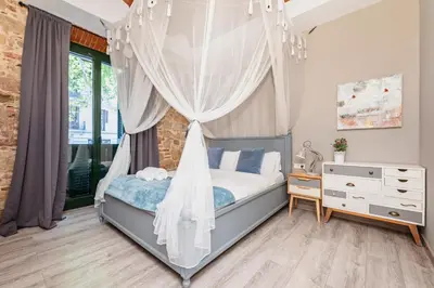 a bedroom with a canopy bed and a dresser at Midtown Luxury Apartments by Sweett in Barcelona