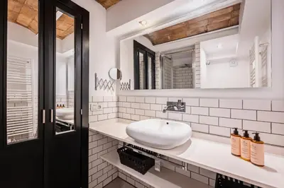 a bathroom with a sink and two mirrors at Midtown Luxury Apartments by Sweett in Barcelona