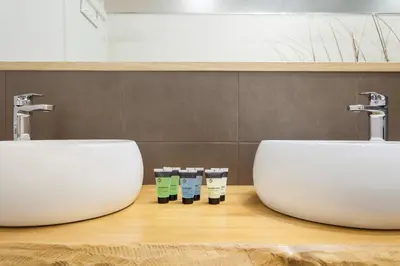two sinks on a wooden counter in a bathroom at Art House Granvia in Barcelona