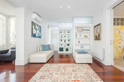 a living room with white furniture and a rug at Art House Granvia in Barcelona