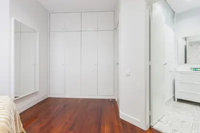 a bedroom with white closets and a wooden floor at Art House Granvia in Barcelona