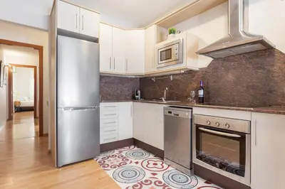 a kitchen with white cabinets and stainless steel appliances at Art House Sagrada Familia in Barcelona