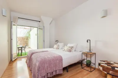 a white bedroom with a bed and a sliding glass door at Art House Sagrada Familia in Barcelona