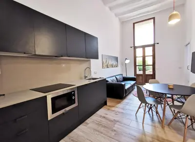 a kitchen and living room with a table and chairs at ClassBedroom Port Ramblas in Barcelona