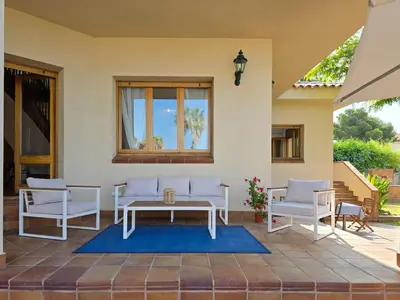 a patio with a table and chairs and a window at Villa El Faro by Hello Homes Sitges in Vilanova i la Geltrú