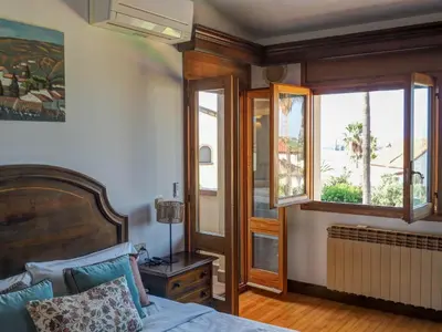 a bedroom with a bed and a window at Villa El Faro by Hello Homes Sitges in Vilanova i la Geltrú