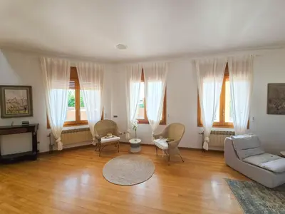 a living room with a couch and chairs and windows at Villa El Faro by Hello Homes Sitges in Vilanova i la Geltrú