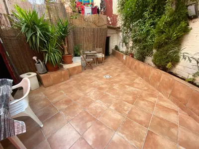 a patio with chairs and plants and a fence at Cozy Suite apartment, WiFi! in Santa Coloma
