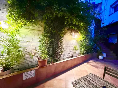 a brick wall with potted plants and a bench at Cozy Suite apartment, WiFi! in Santa Coloma