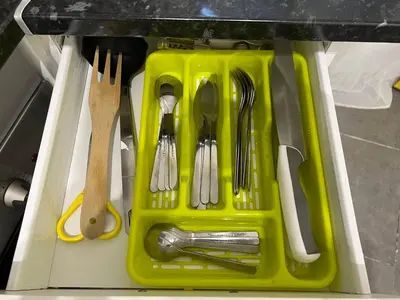 a yellow tray with utensils in a drawer at Cozy Suite apartment, WiFi! in Santa Coloma