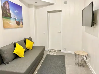 a living room with a gray couch and yellow pillows at Cozy Suite apartment, WiFi! in Santa Coloma