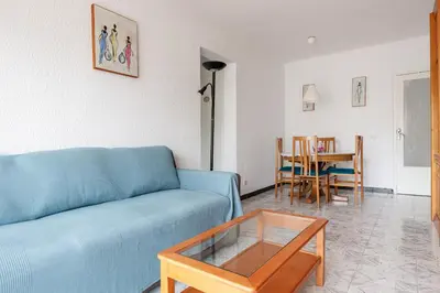 a living room with a blue couch and a table at Besos · Bright apartment close to congress & port in Sant Adria de Besos