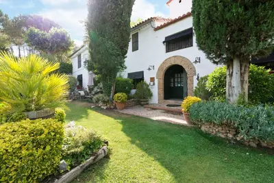 a white house with a yard with plants at Comarquinal Bioresort Penedes in San Quintín de Mediona