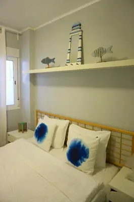 a bedroom with a bed with blue fluffy pillows at Cala Balmins Sea View in Sitges