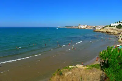 a group of people in the water at a beach at Cala Balmins Sea View in Sitges