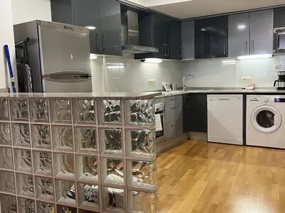 a kitchen with black cabinets and white appliances at Stay Barcelona Maragall in Barcelona