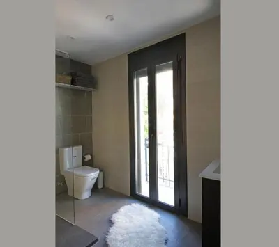 a bathroom with a toilet and a window at Fridays Flats Casa Lemonade in Hospitalet de Llobregat