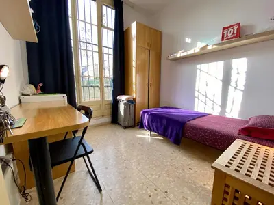 a bedroom with a bed and a desk and window at Barcelona Housing recommend for Students in Barcelona