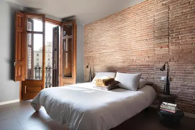 a bedroom with a brick wall and a large bed at DestinationBCN Universitat Apartments in Barcelona