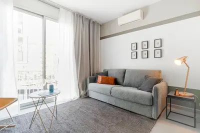 a living room with a couch and a large window at Sweett - Callao Plaza in Barcelona