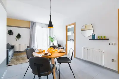 a dining room and living room with a table and chairs at Sweett - Callao Plaza in Barcelona