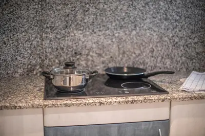 a stove top with two pans on top of it at Aparthotel Marsol in Castelldefels