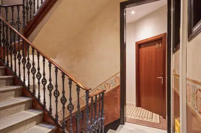 a hallway with stairs and a wooden door at Central Apartments Barcelona in Barcelona