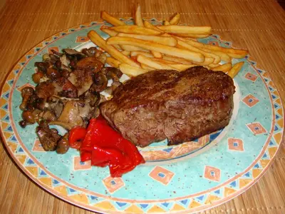 a plate of food with a steak and french fries at Casablanca Suites - Adults Only in Calella