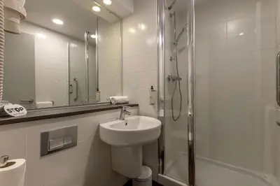 a white bathroom with a sink and a shower at Travelodge Barcelona Poblenou in Barcelona