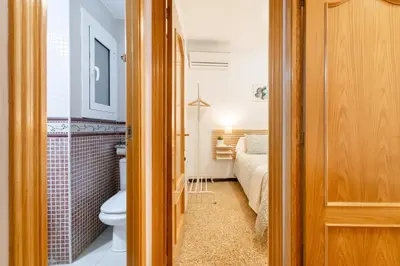 a bathroom with a toilet and a bed in a room at Confort Barcelona Rentals in Barcelona
