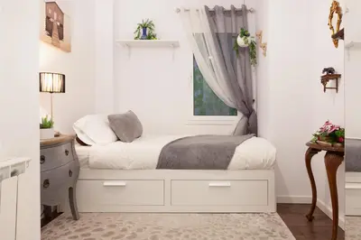 a white bedroom with a bed and a window at Rambla Poblenou&Mar Bella Beach in Barcelona
